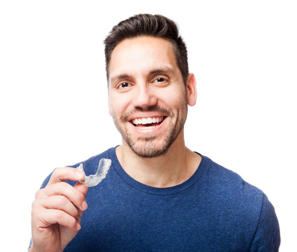 A man in a blue shirt is holding a clear brace in his hand.