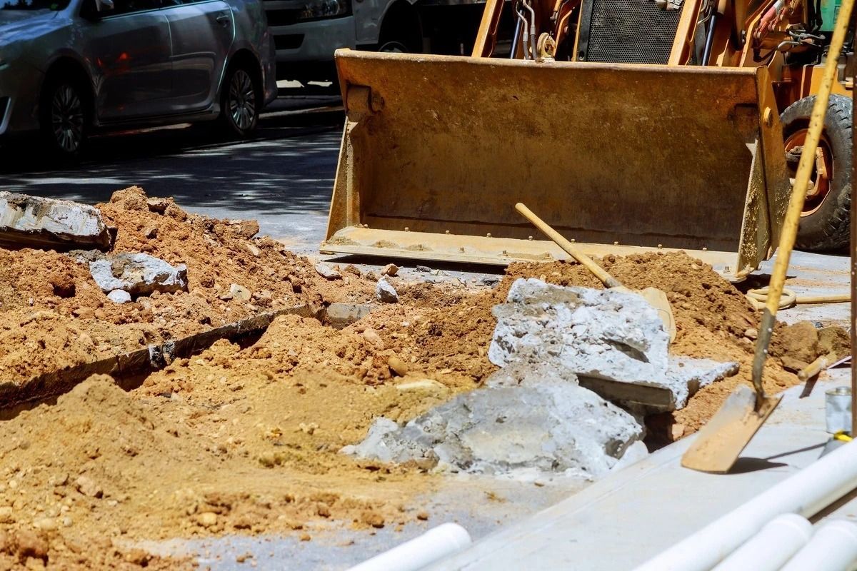 A bulldozer is digging a hole in the ground on a construction site.