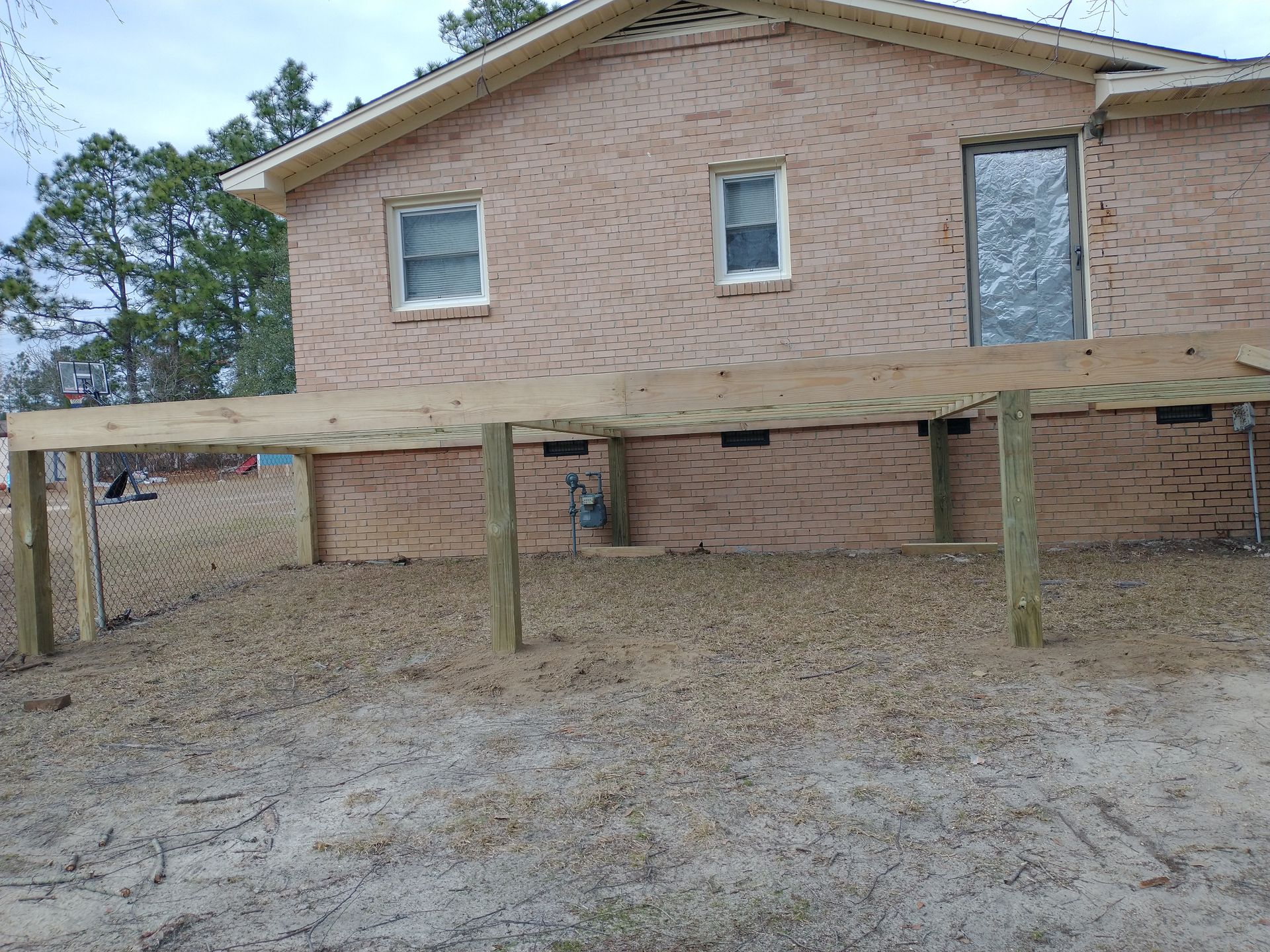 A brick house with a wooden deck in front of it.