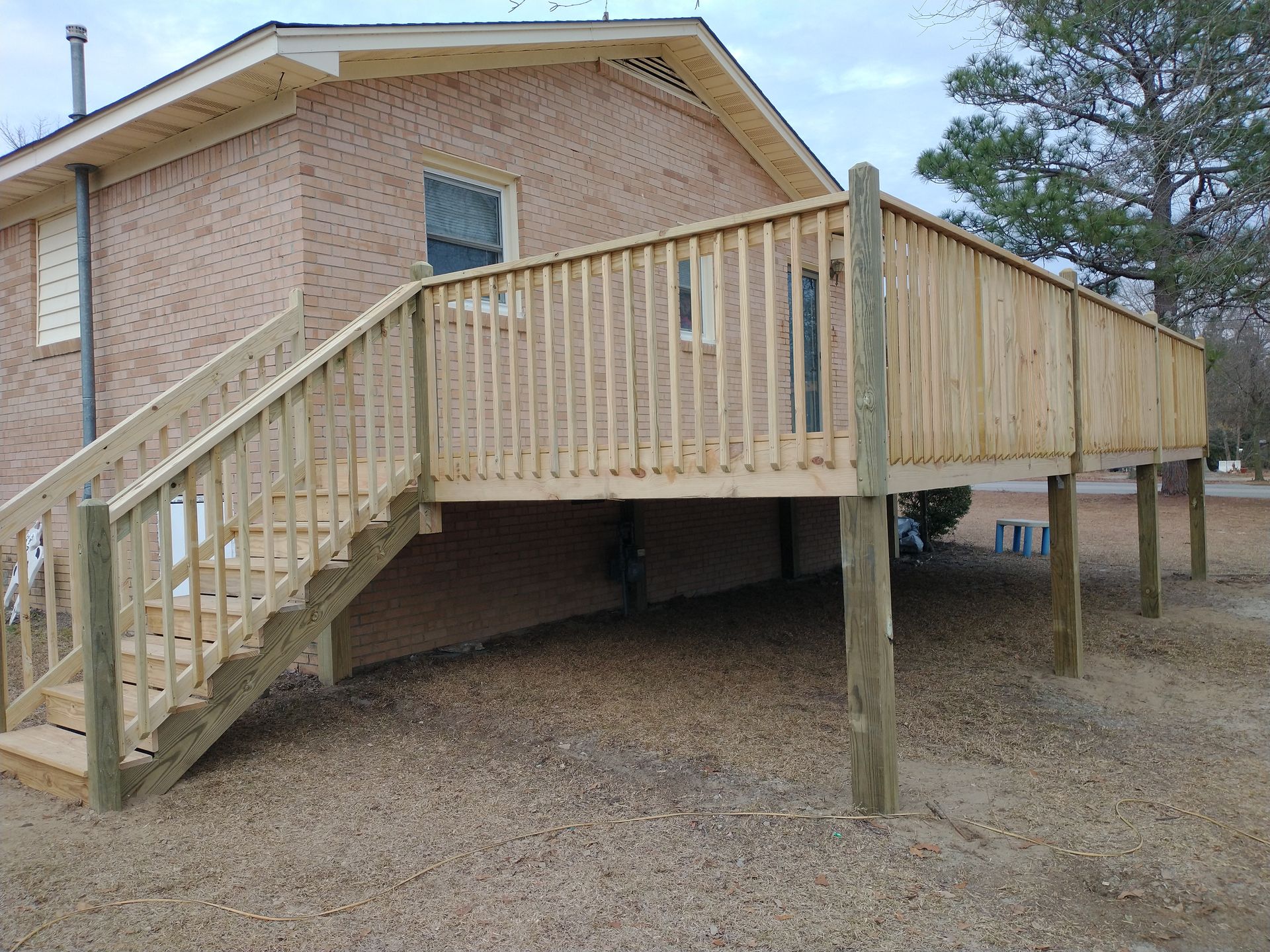 A brick house with a wooden deck and stairs
