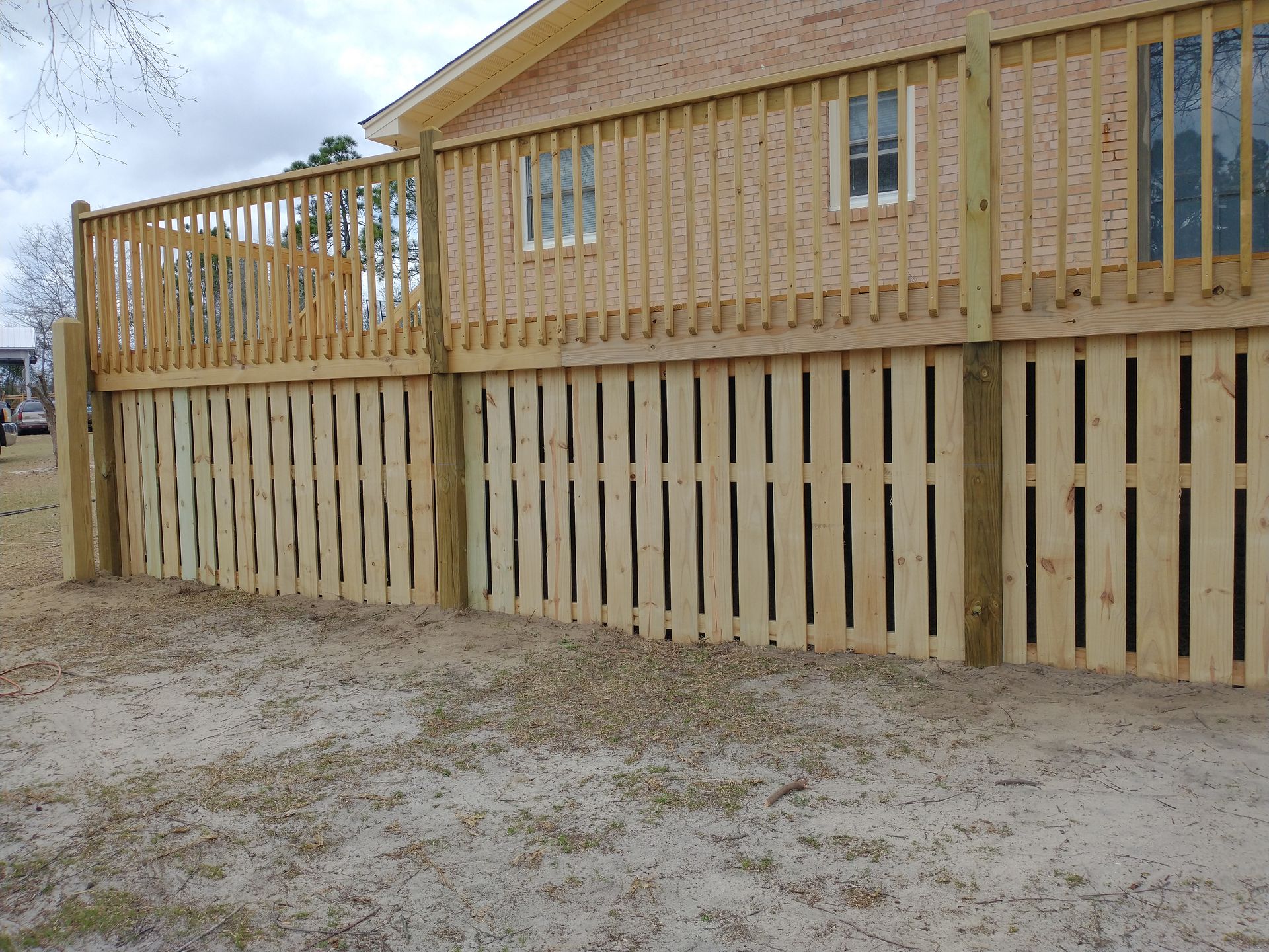A house with a wooden deck and fence in front of it