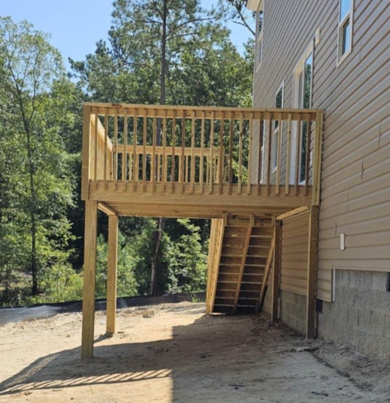 A house with a wooden deck and stairs underneath it
