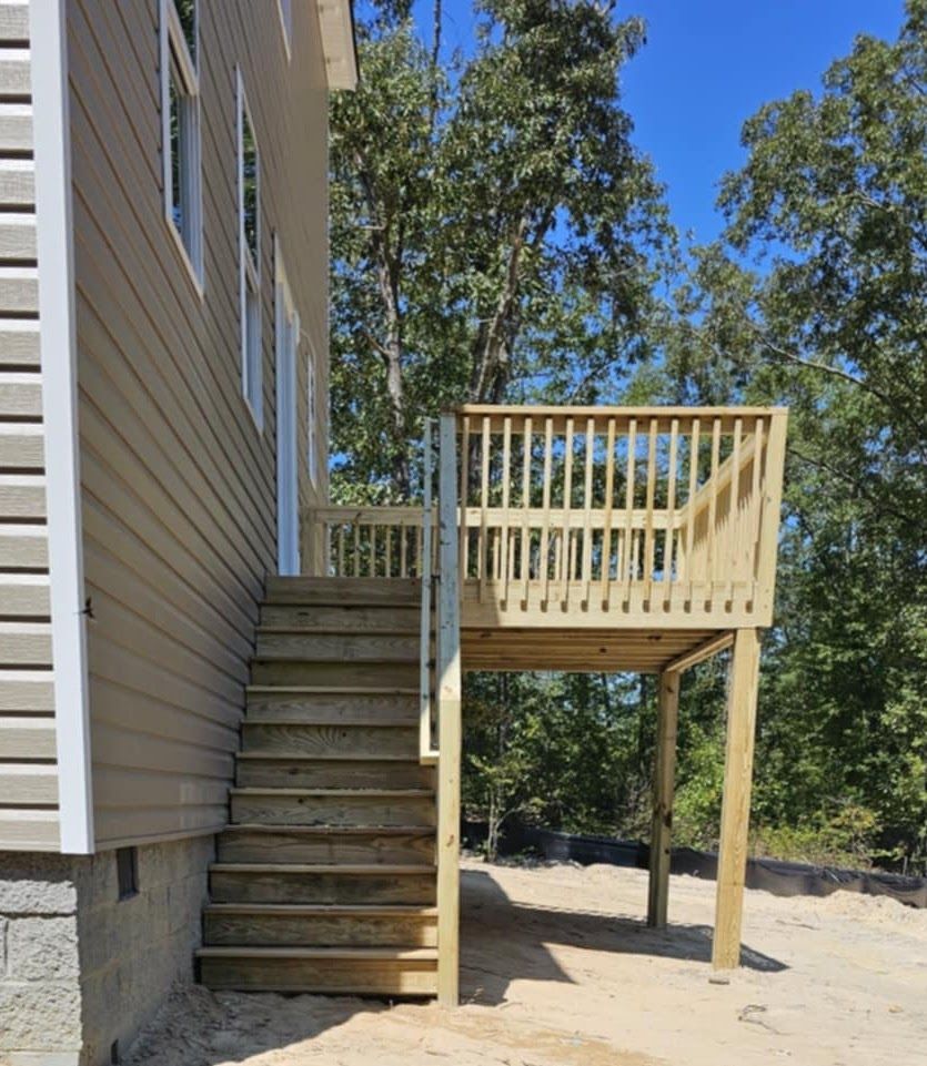 A house with stairs leading up to a wooden deck