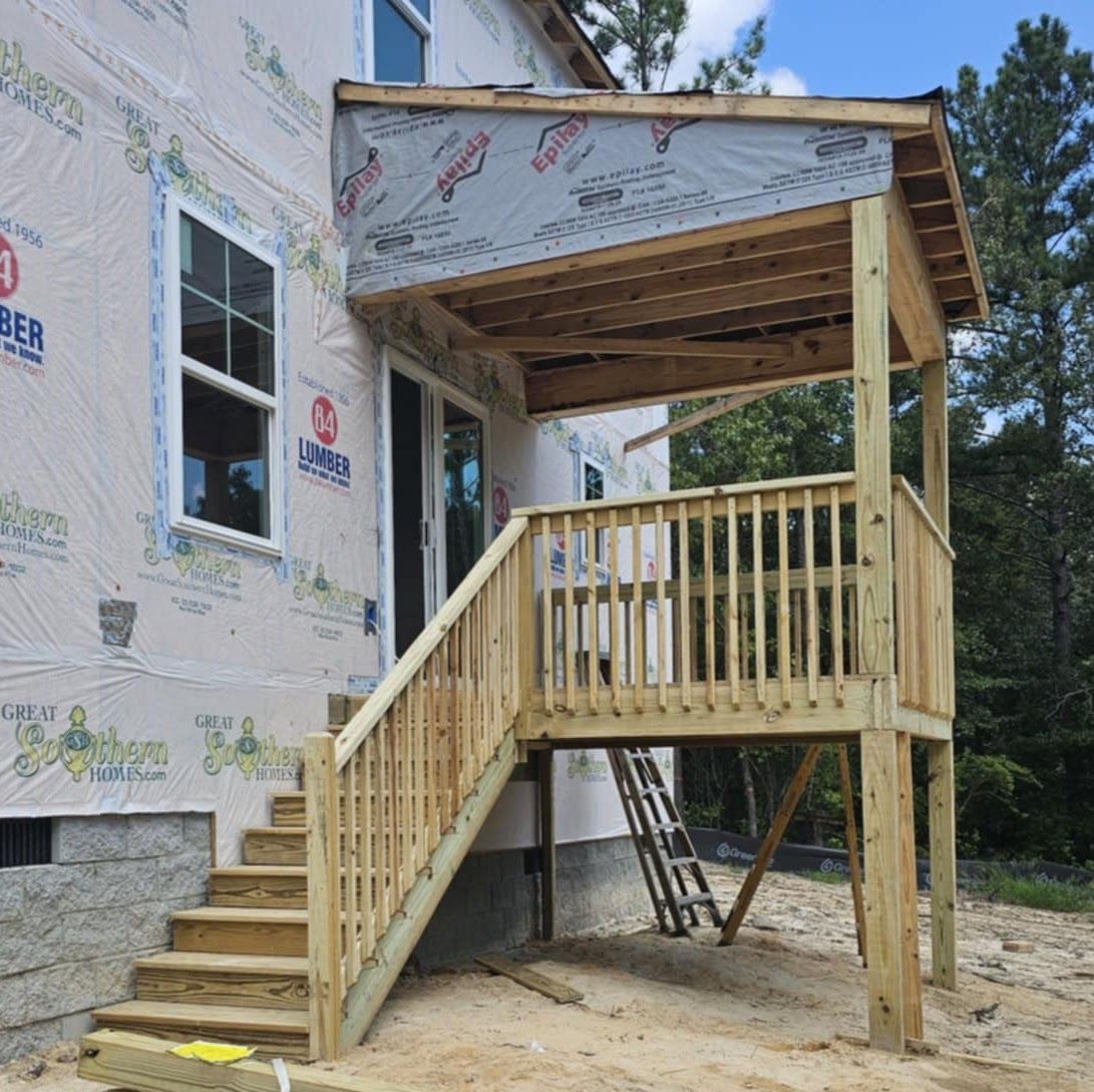 A house under construction with a wooden deck and stairs