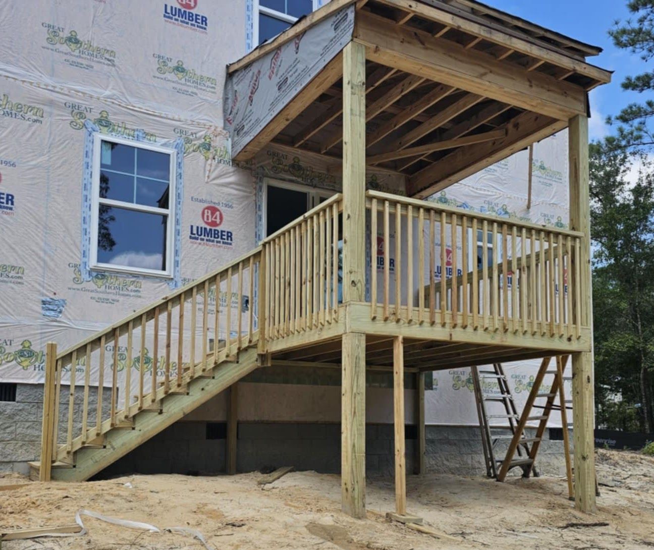 A house under construction with a wooden deck and stairs