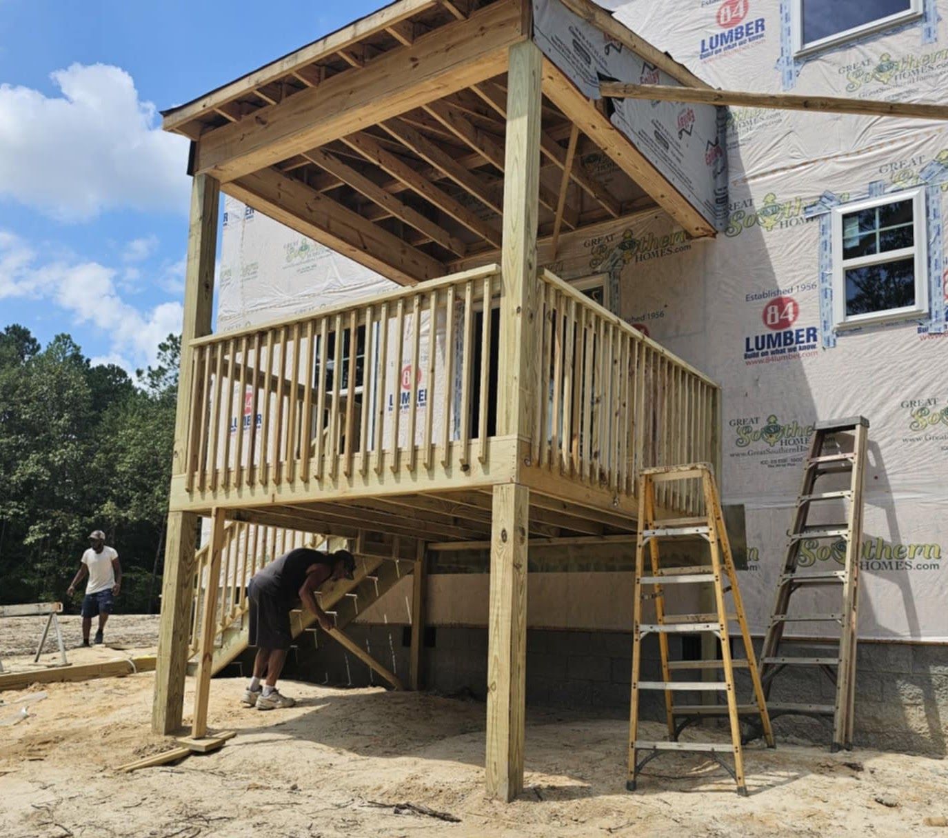 A wooden deck is being built on the side of a house