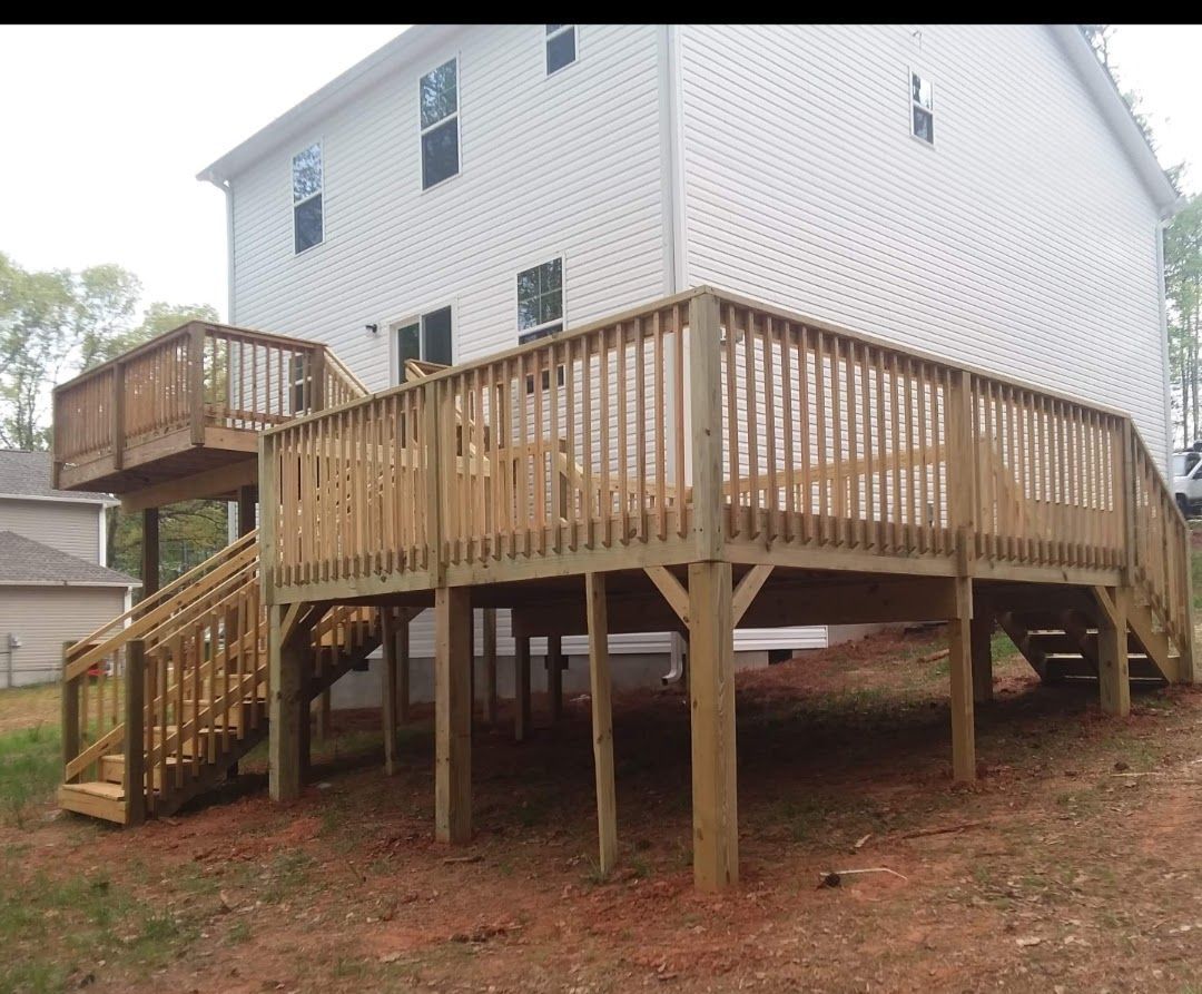A large white house with a wooden deck and stairs