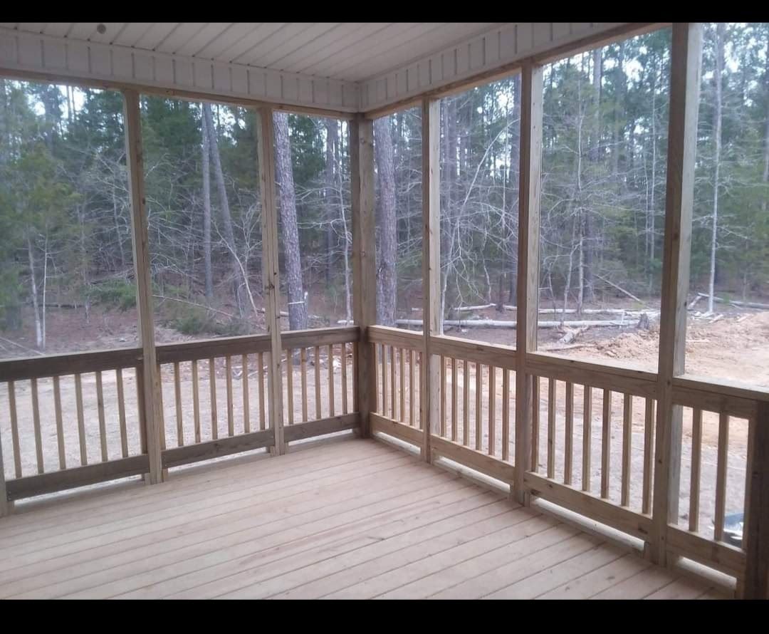 A screened in porch with a view of the woods