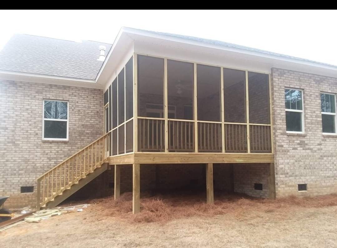 A house with a screened in porch and stairs.