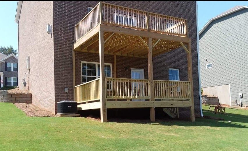 A brick house with a wooden deck in front of it