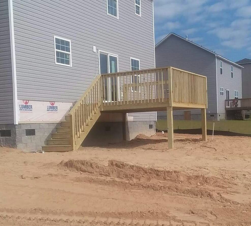A house with a deck and stairs in front of it
