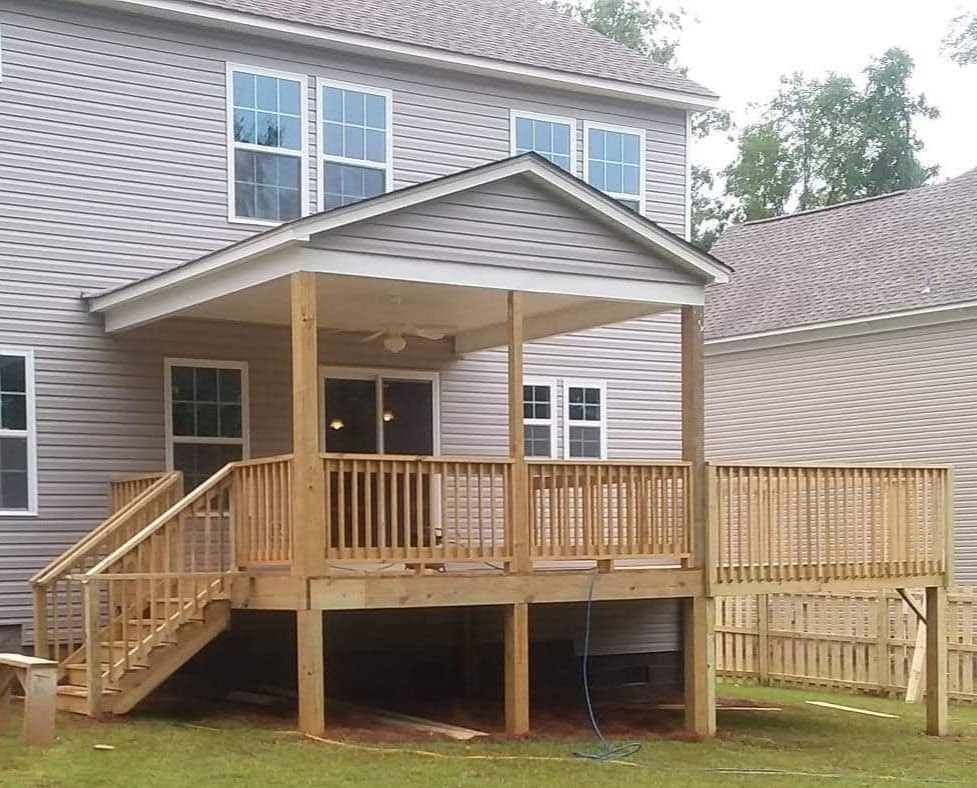 The back of a house with a wooden deck and stairs