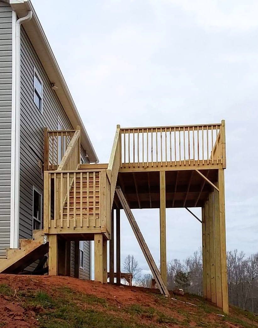 A house with a wooden deck on the side of it