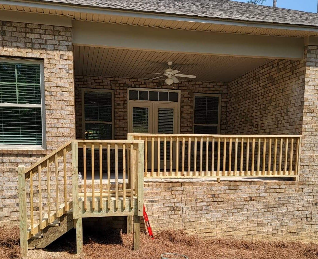 A brick house with a wooden deck and stairs