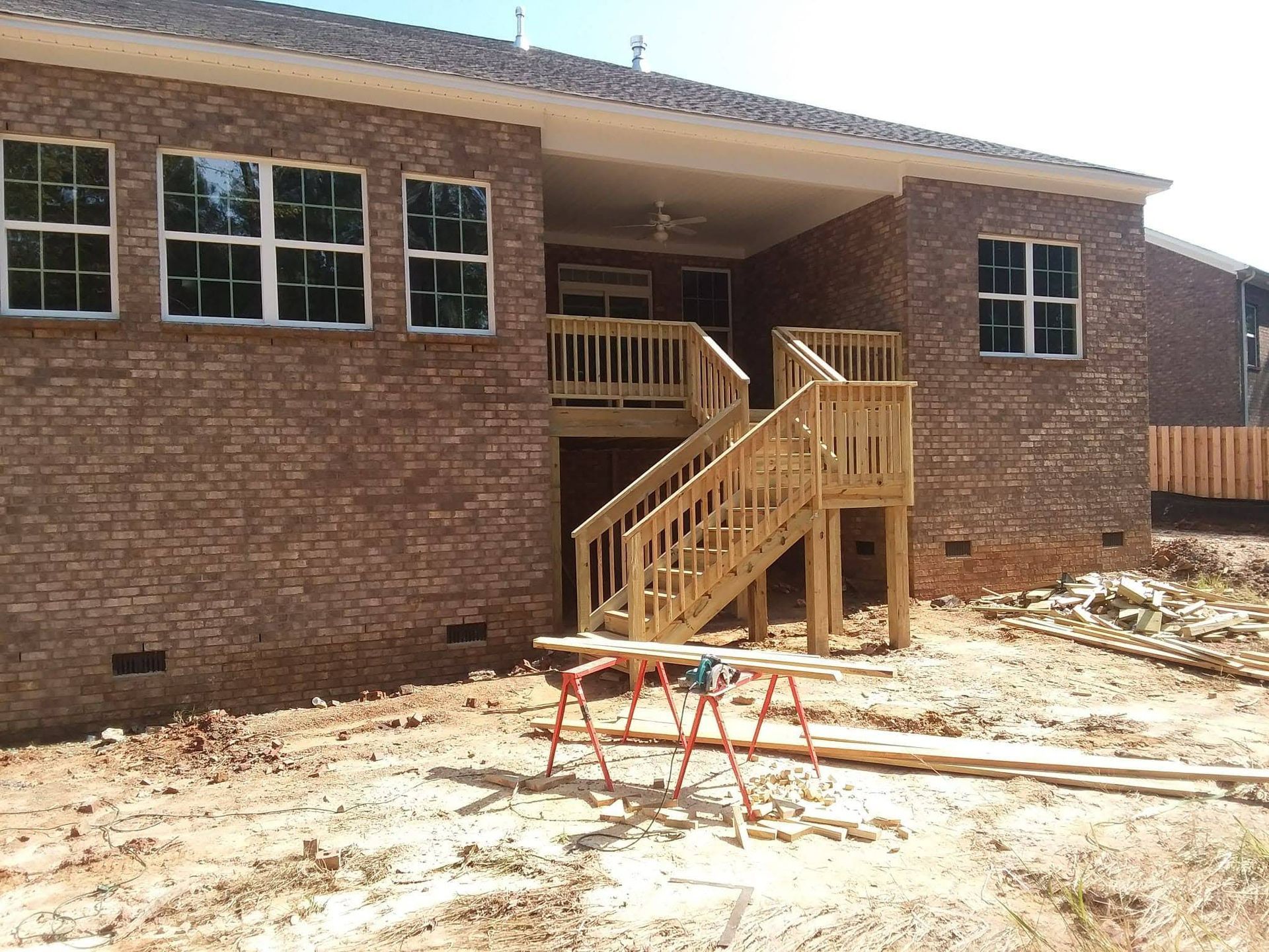 A brick house with a wooden deck and stairs
