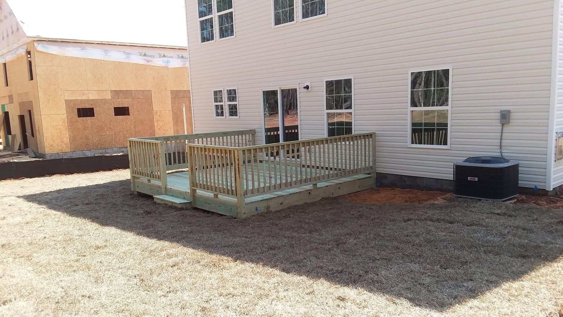 A white house with a wooden deck in front of it