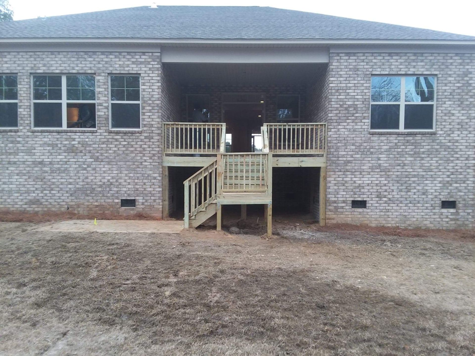 A brick house with a wooden deck and stairs