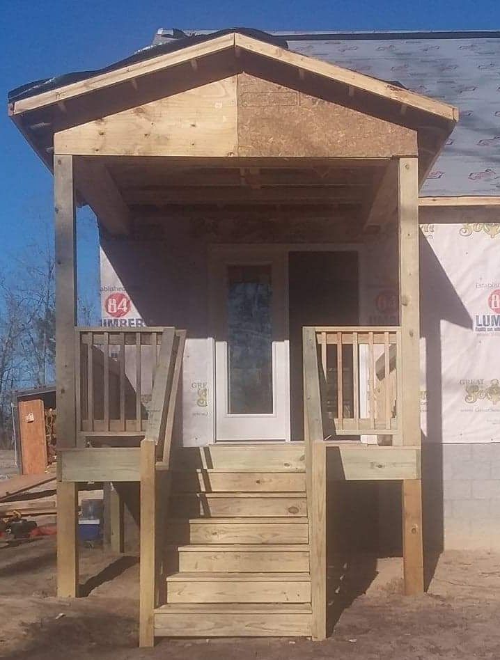 A house under construction with a porch and stairs