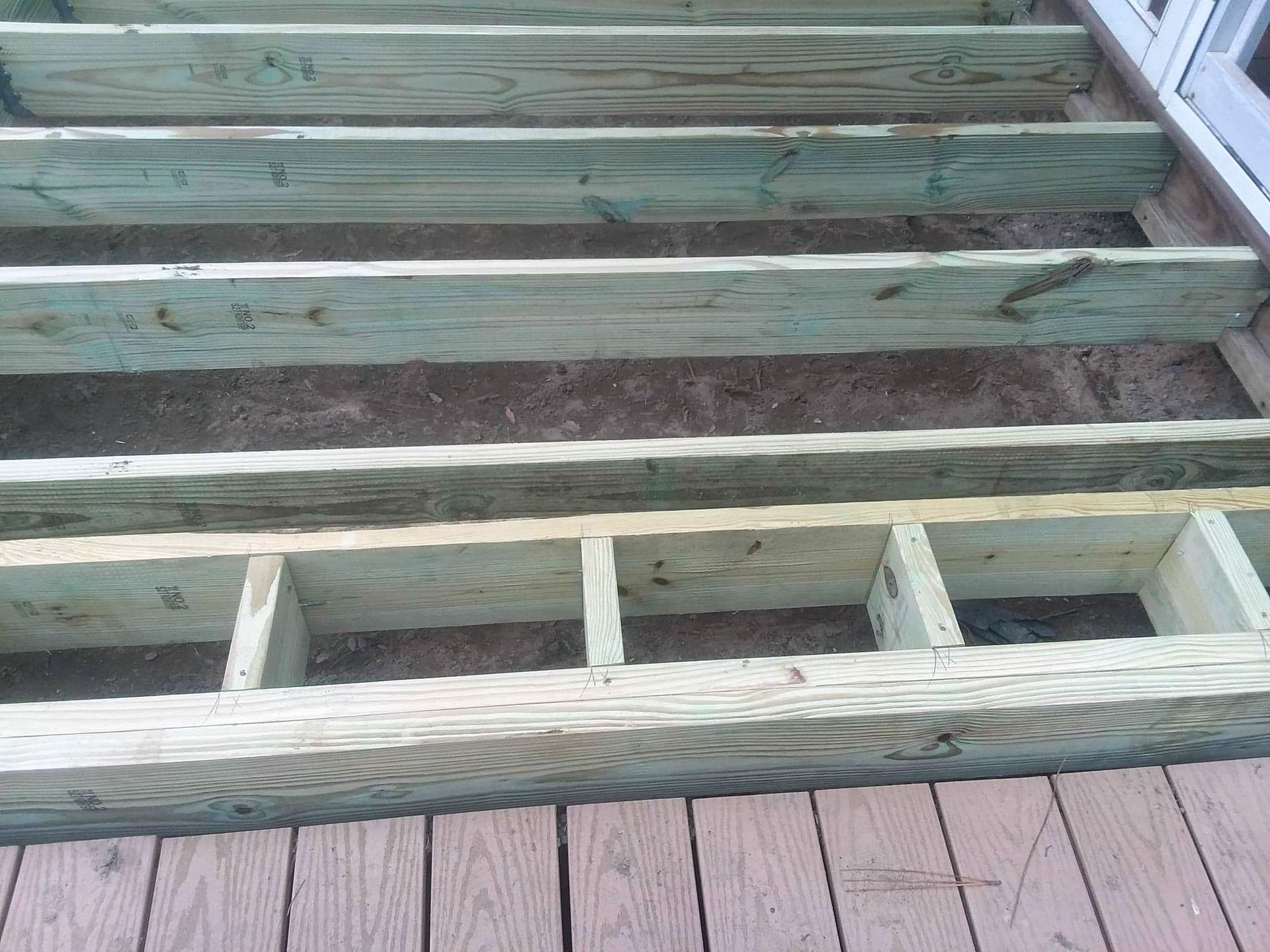 A close up of a wooden deck under construction.