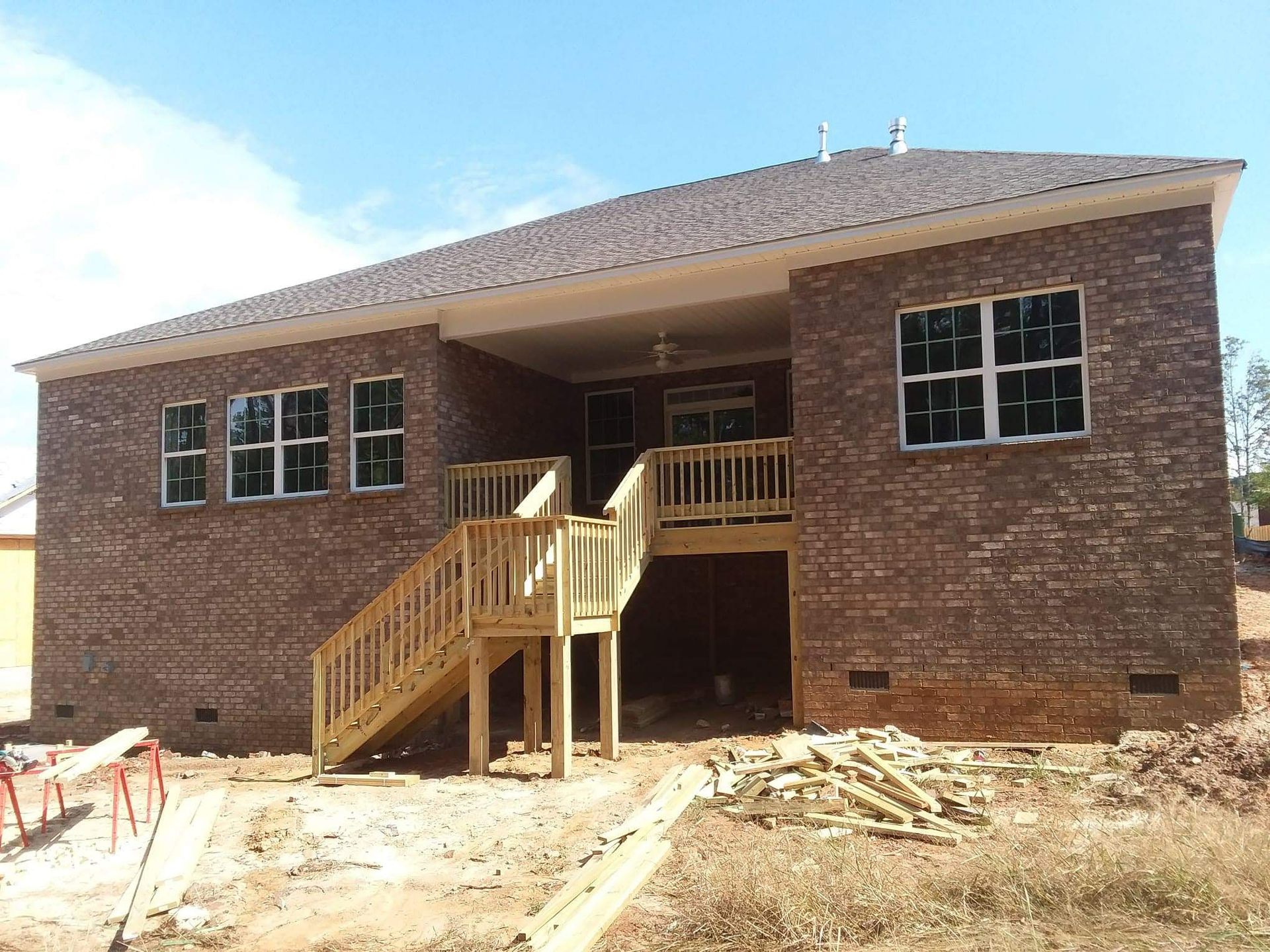 A brick house with a wooden deck and stairs