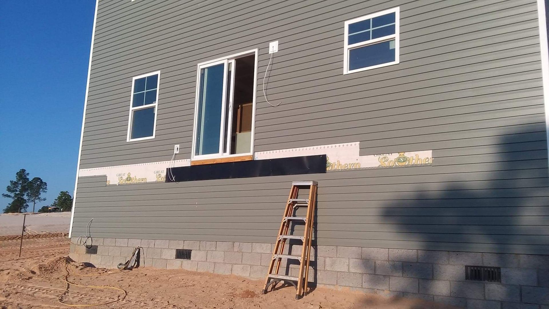 A house under construction with a ladder in front of it