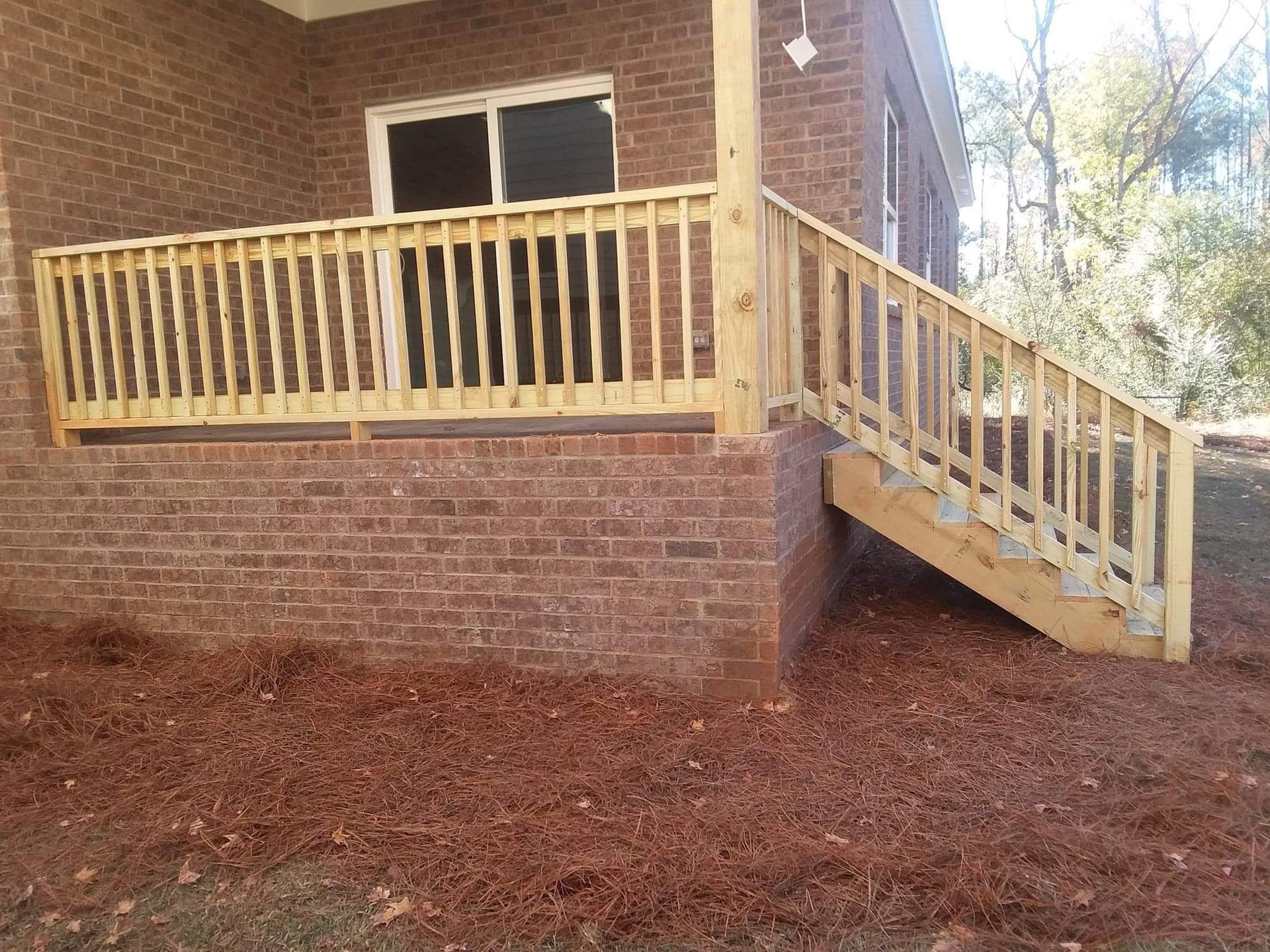 A brick house with a wooden deck and stairs