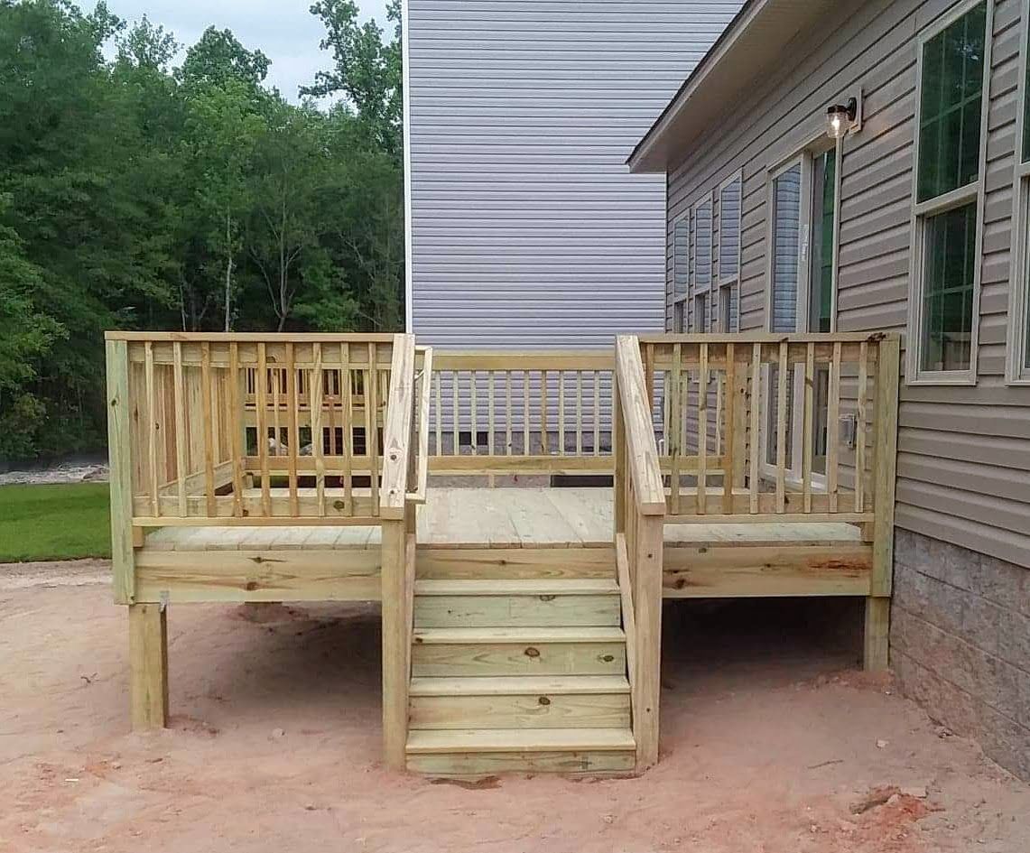 A wooden deck with stairs in front of a house