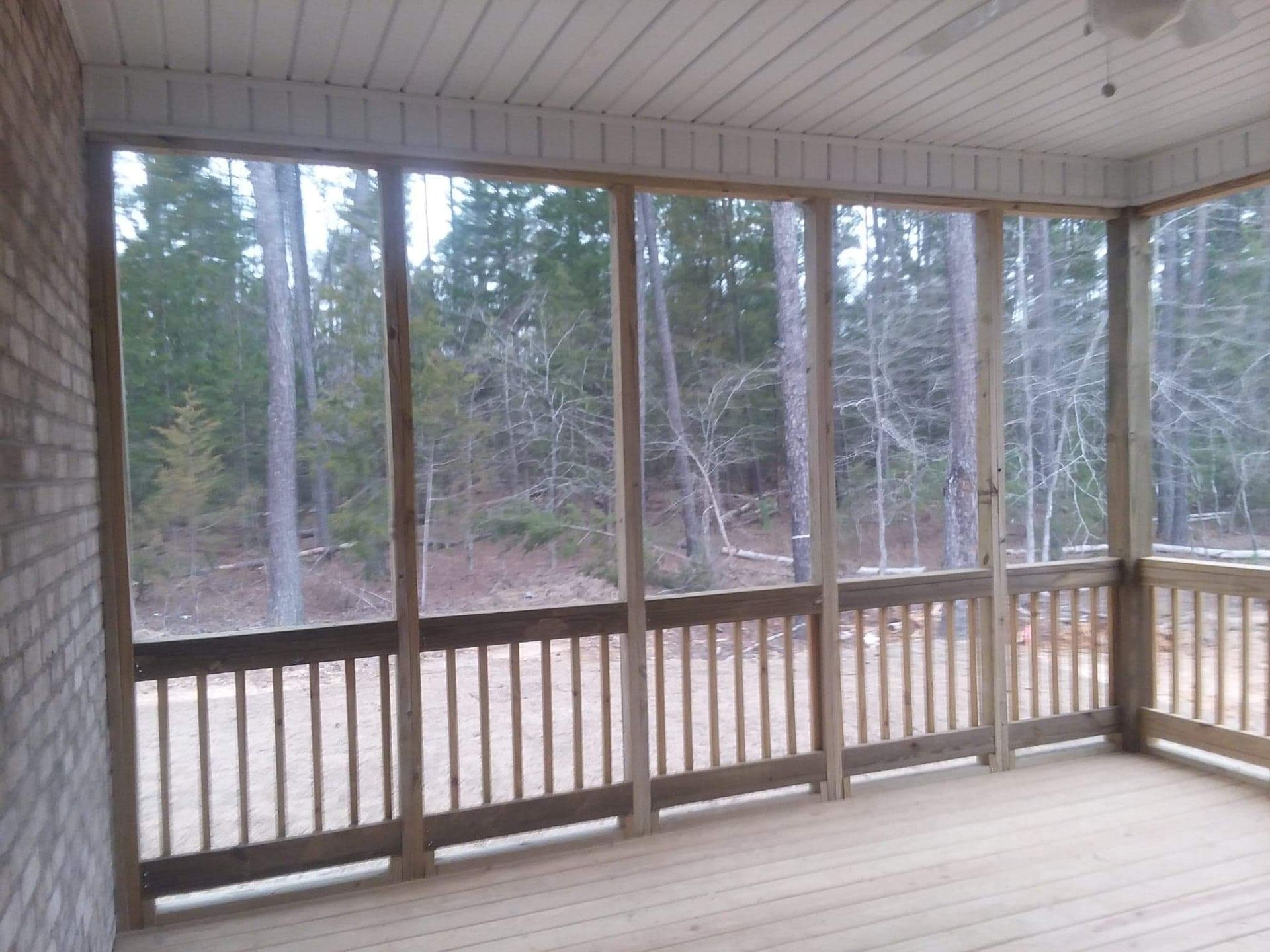 A screened in porch with trees in the background