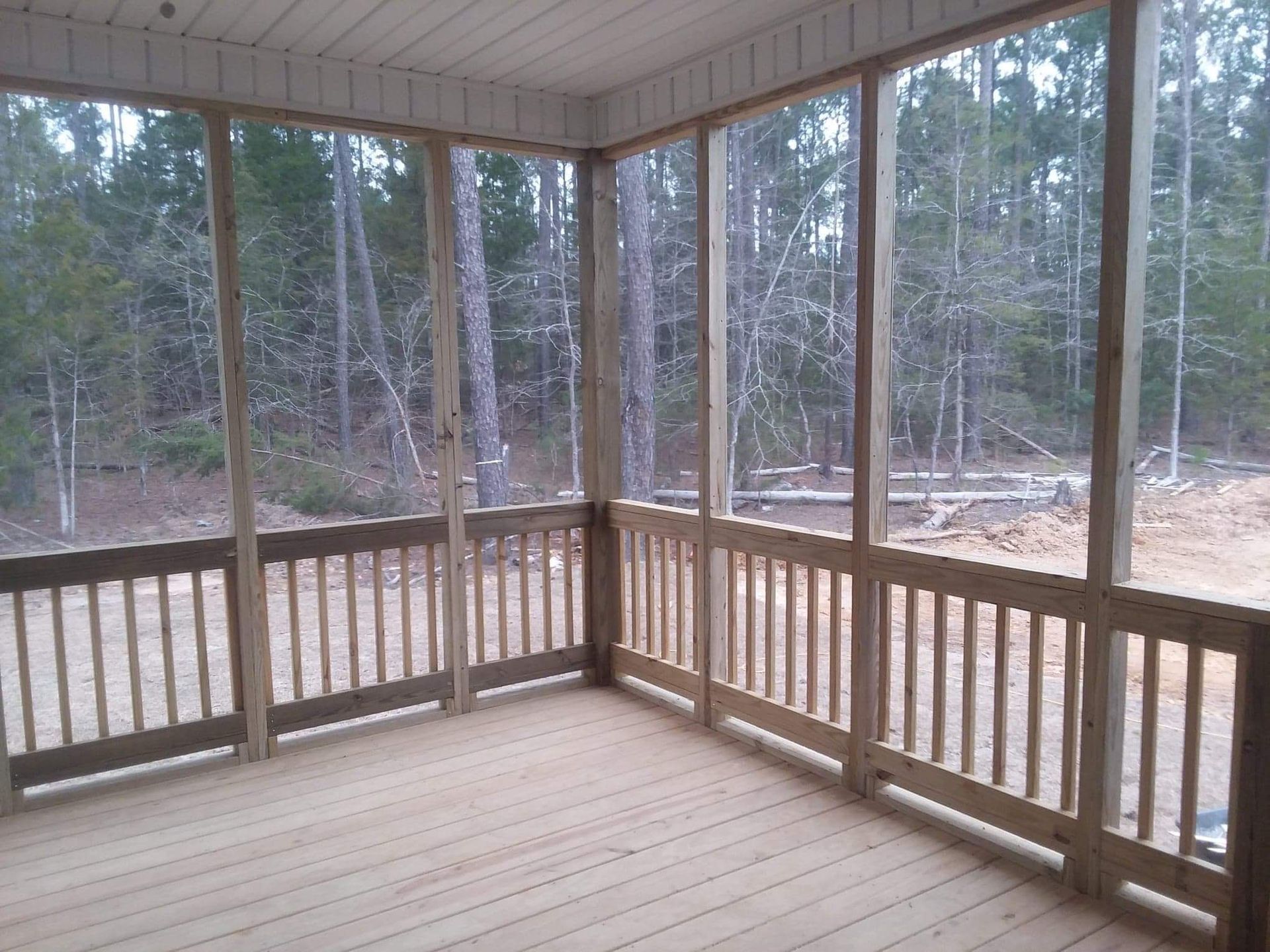A screened in porch with trees in the background