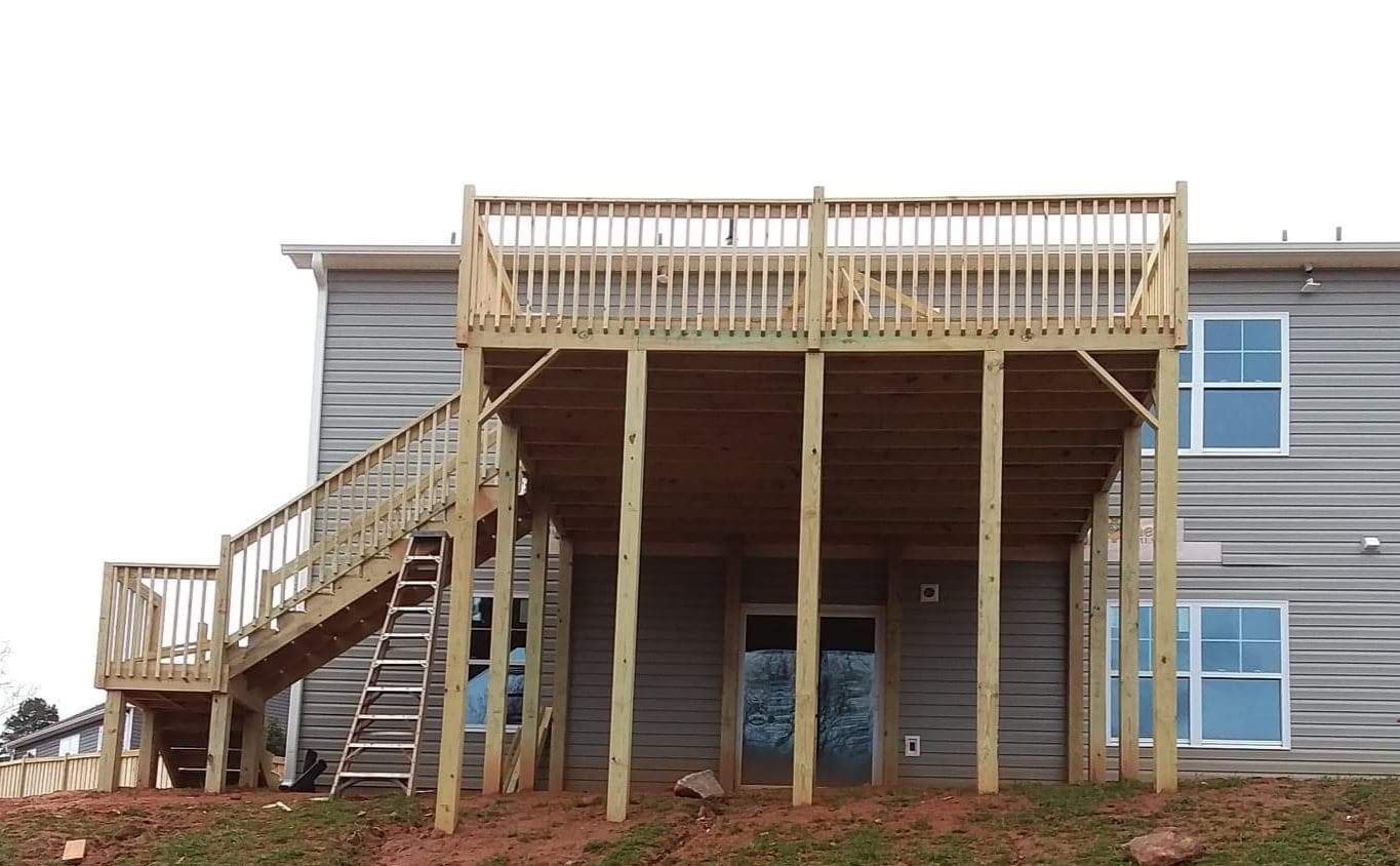 A house with a large wooden deck and stairs