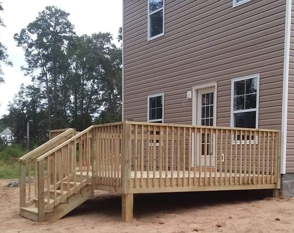A house with a large wooden deck in front of it