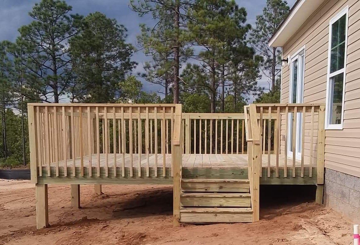 A wooden deck with stairs is in front of a house.