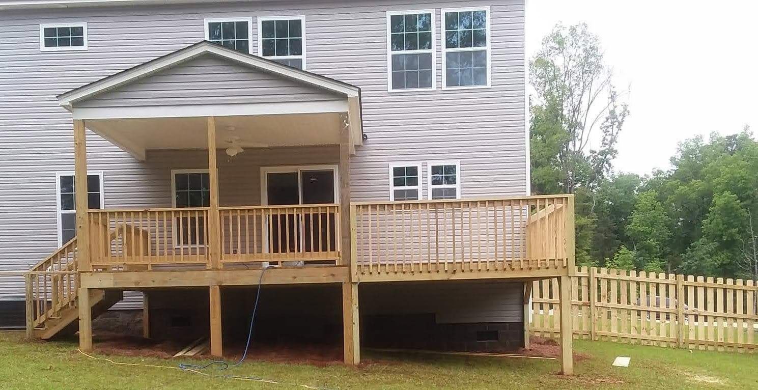 A house with a large wooden deck in front of it