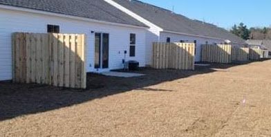 A row of houses with wooden fences in front of them.