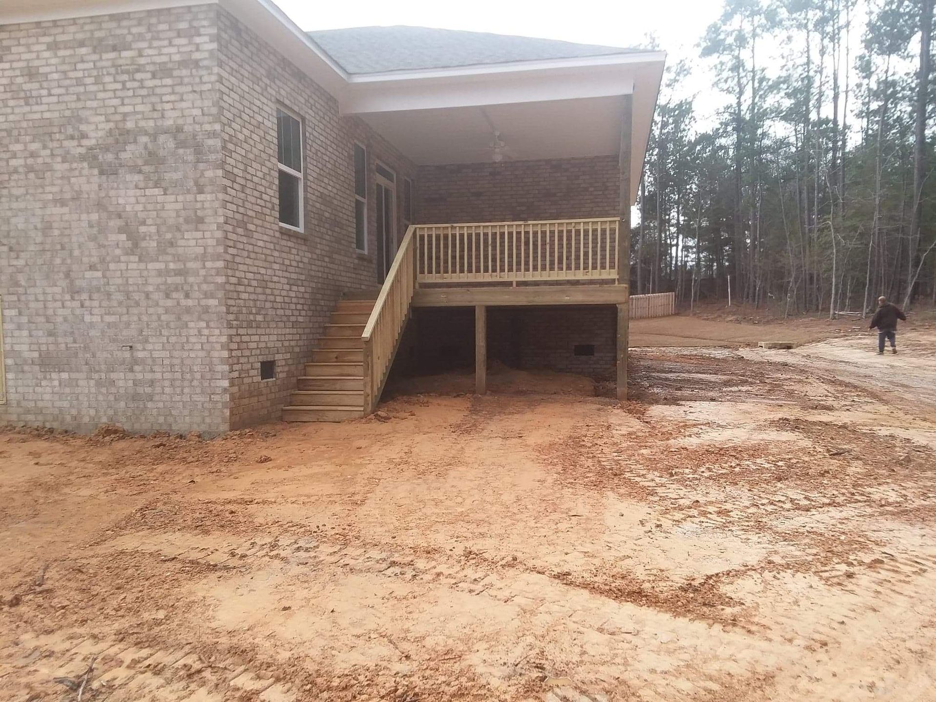 A brick house with a wooden deck and stairs