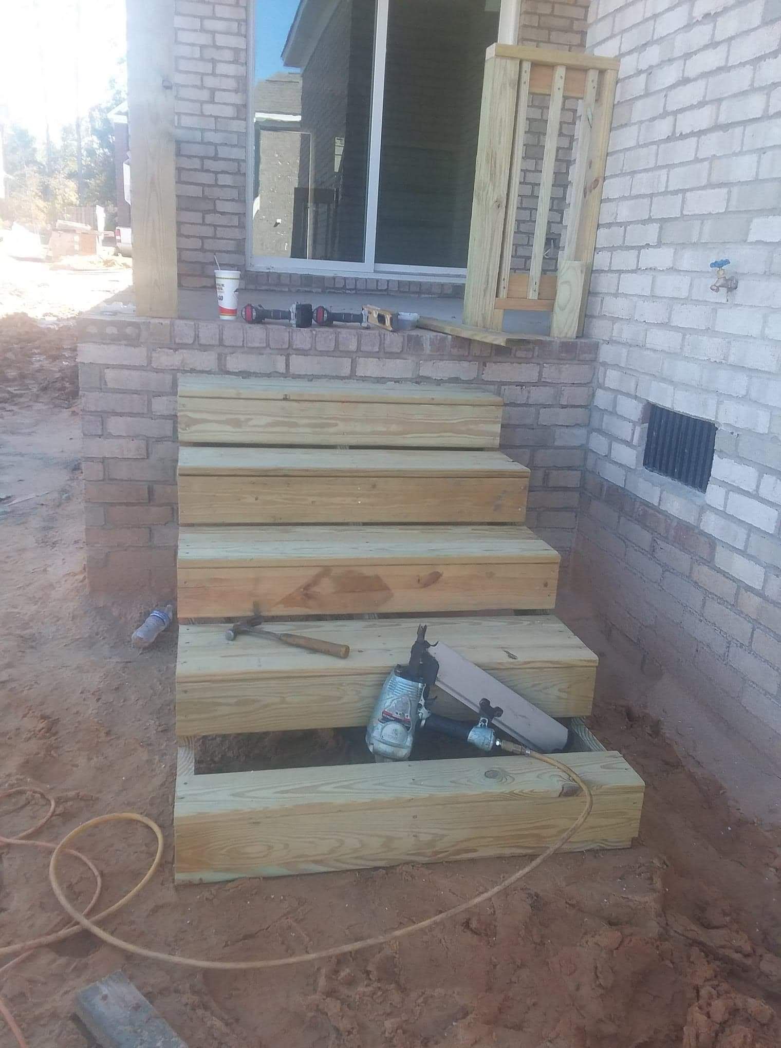 A wooden staircase is being built in front of a brick building.