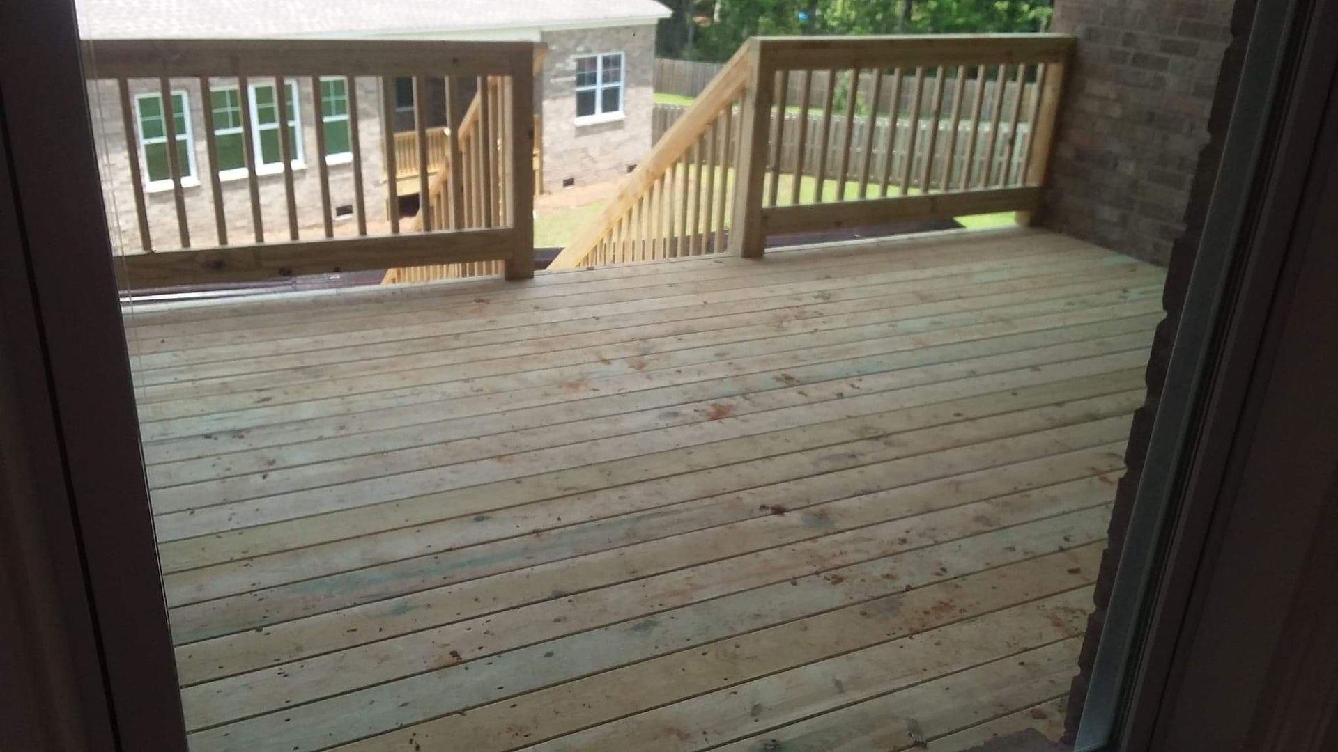 A wooden deck with a wooden railing and stairs