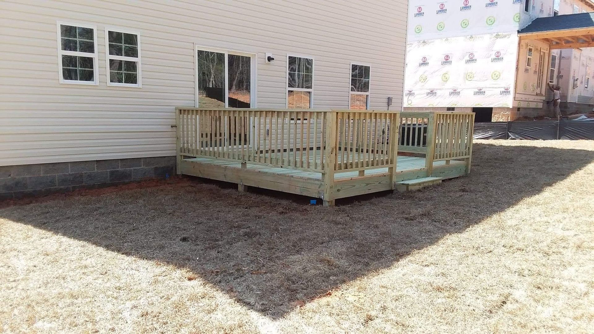 A white house with a wooden deck in front of it