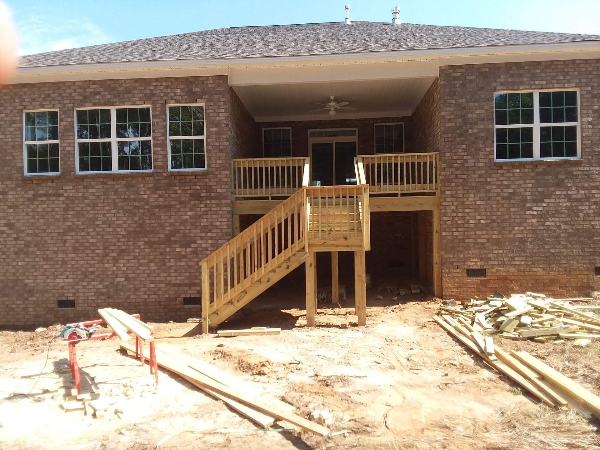 A brick house with a wooden deck and stairs