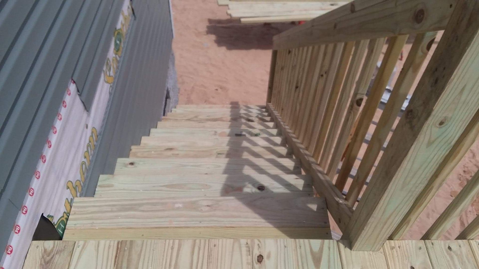 A wooden staircase leading up to a house under construction.