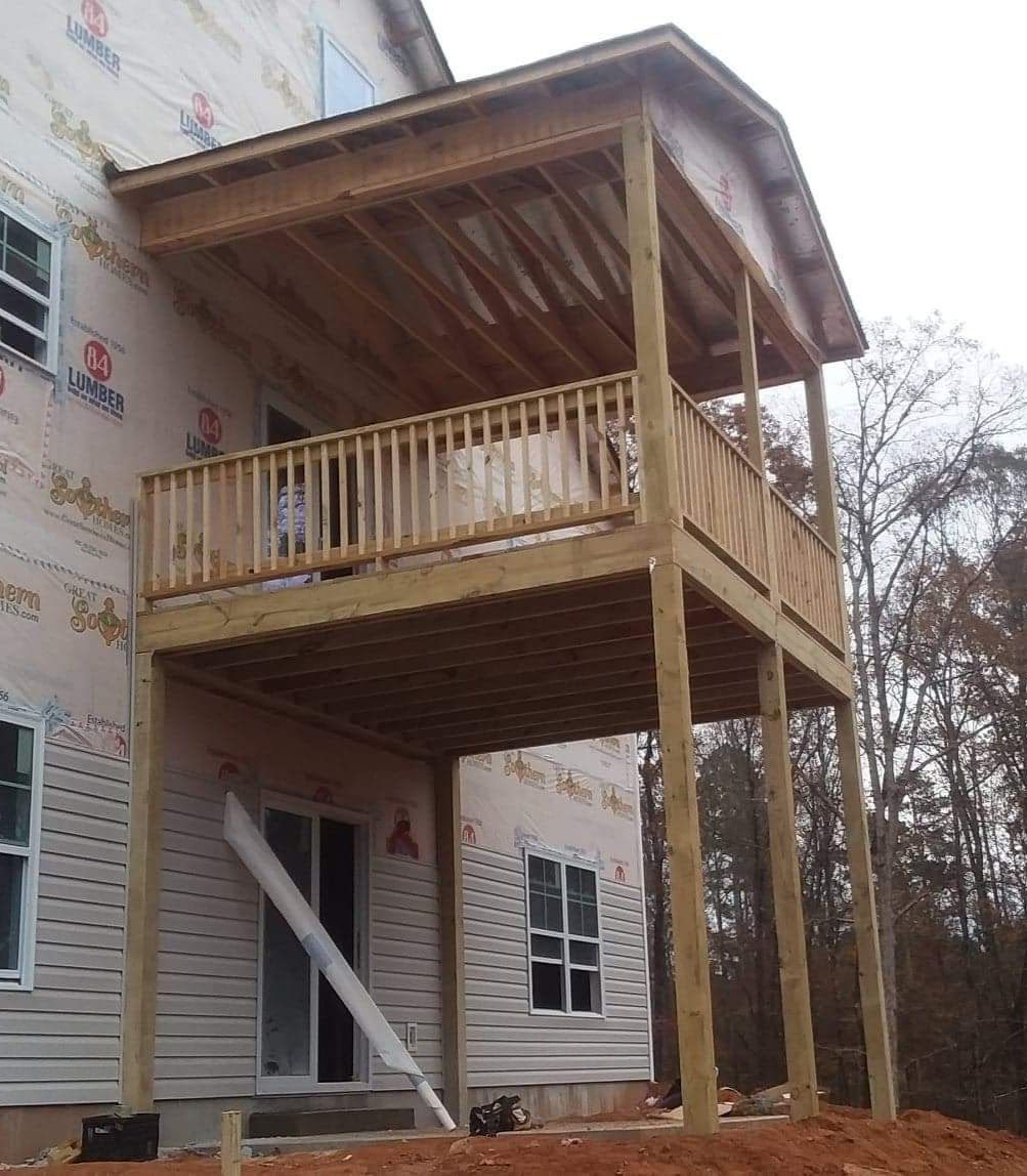 A house under construction with a wooden deck