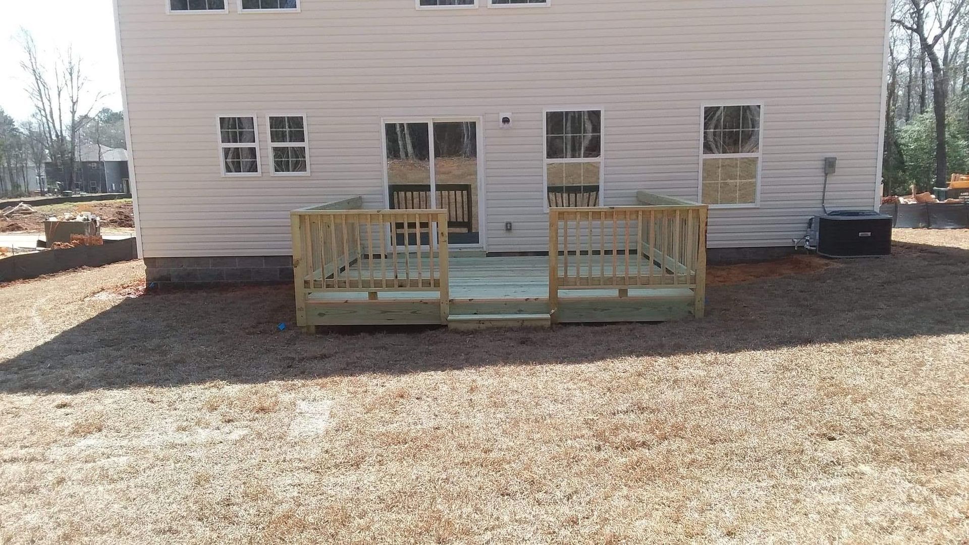 A white house with a wooden deck in front of it