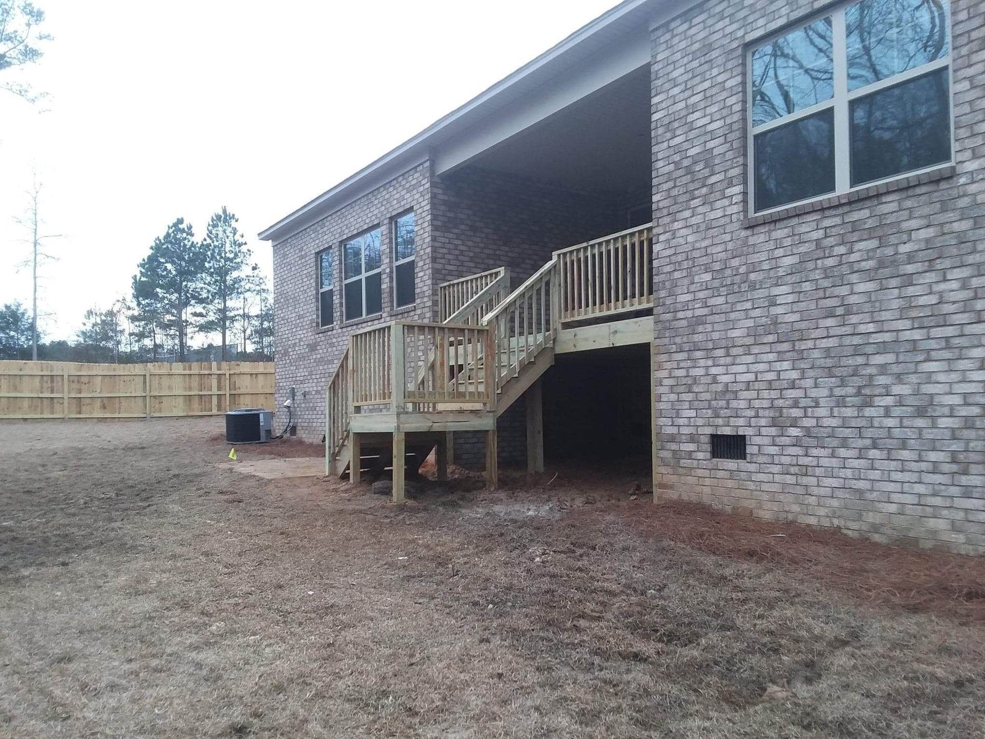 A brick house with a wooden deck and stairs