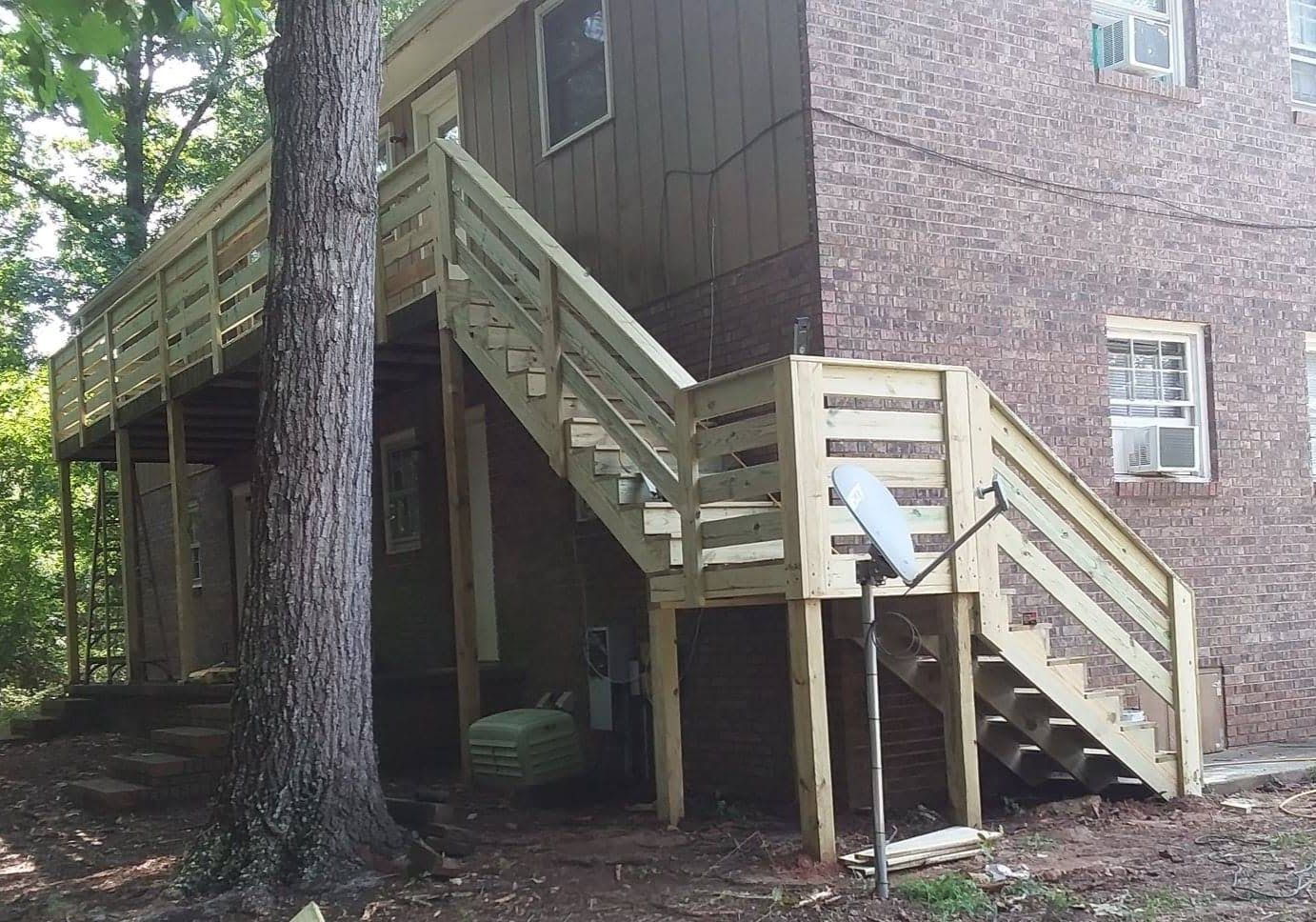 A brick house with a wooden deck and stairs