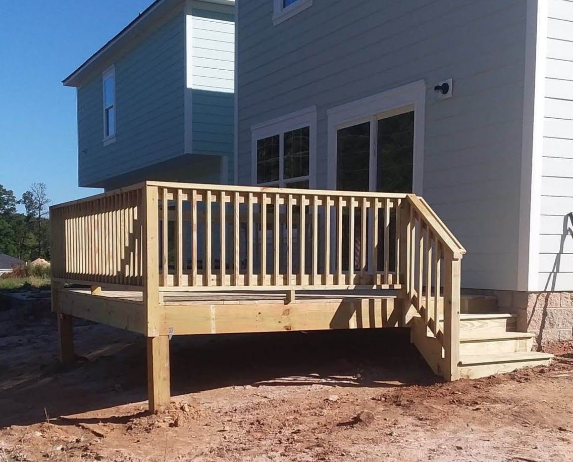A white house with a wooden deck in front of it