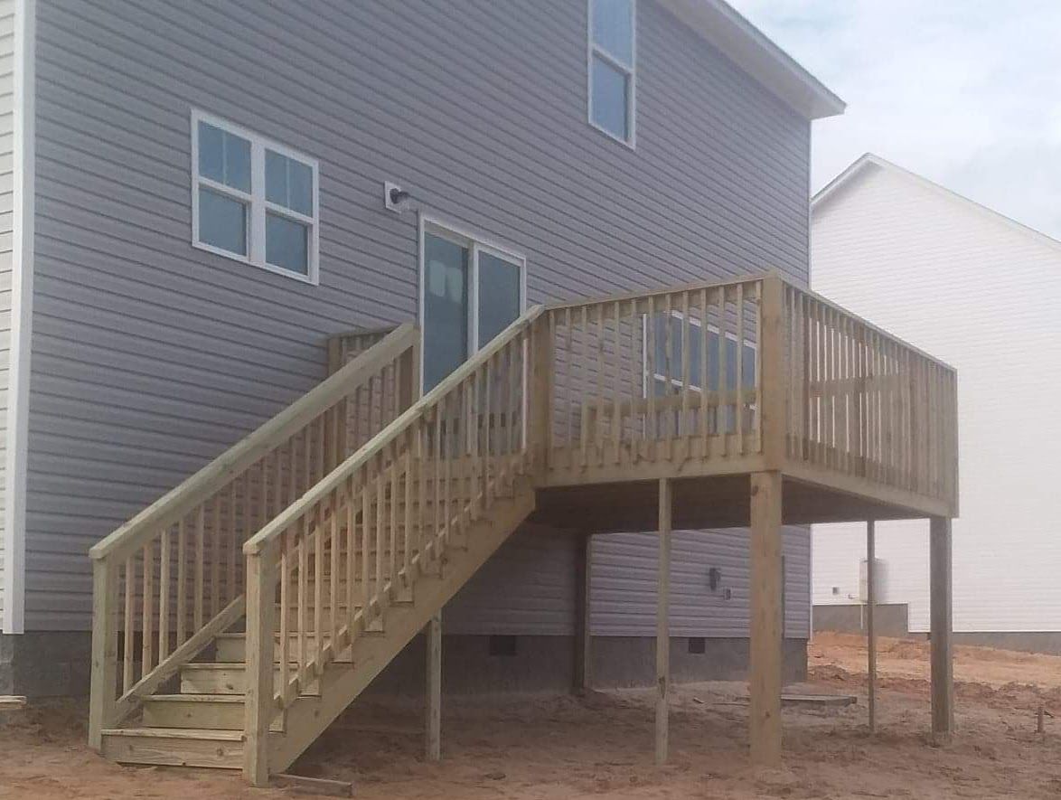 A house with a deck and stairs leading up to it