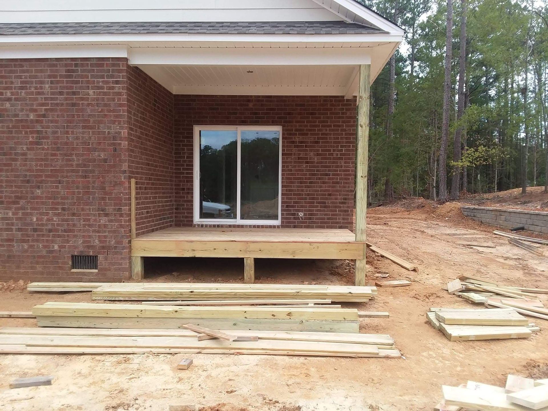 A brick house with a wooden deck in front of it