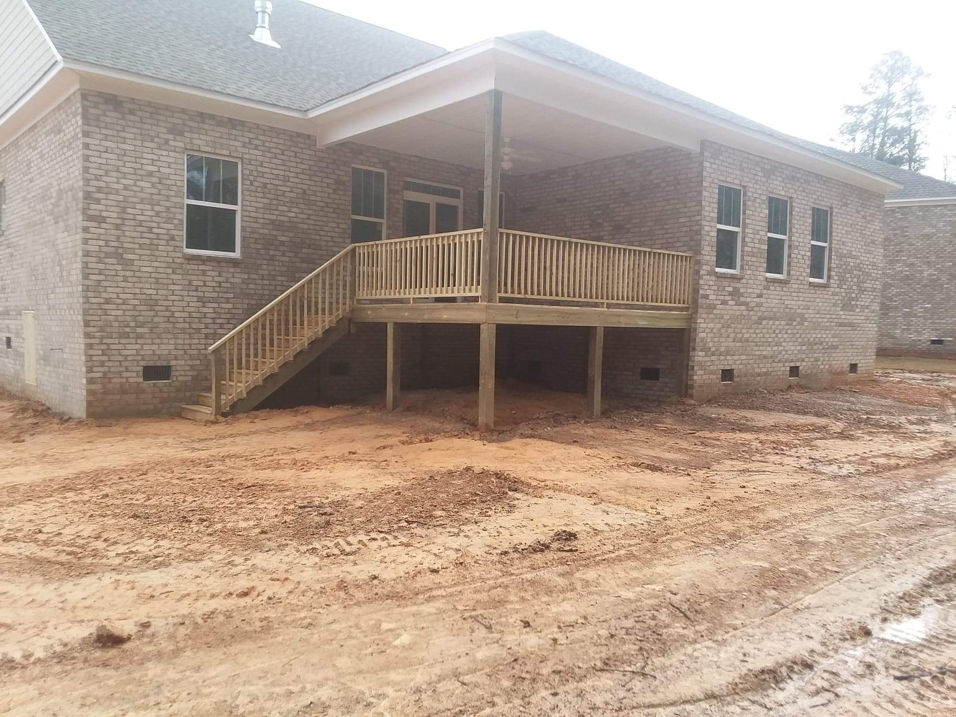 A brick house with a wooden deck and stairs