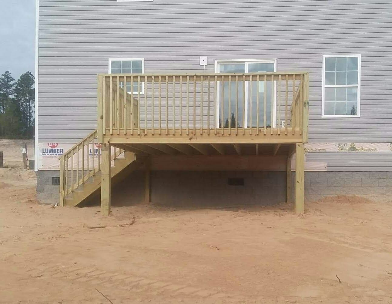 The back of a house with a wooden deck and stairs