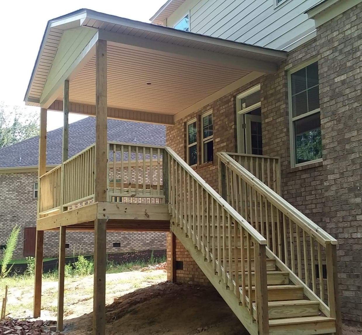 A brick house with a wooden deck and stairs